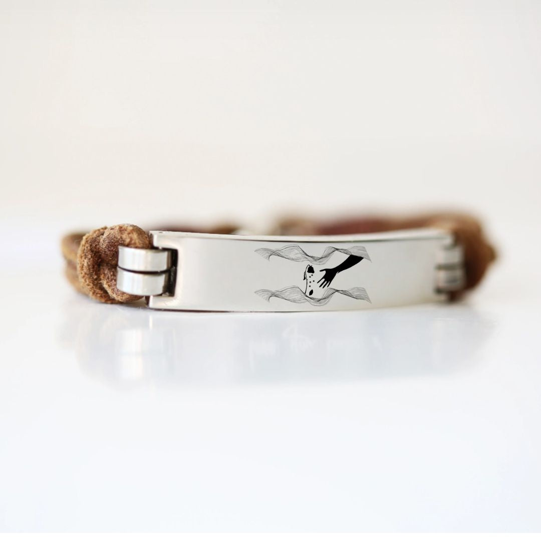 Leather promise bracelet with a silver clasp and engraved promise symbol on a white background.